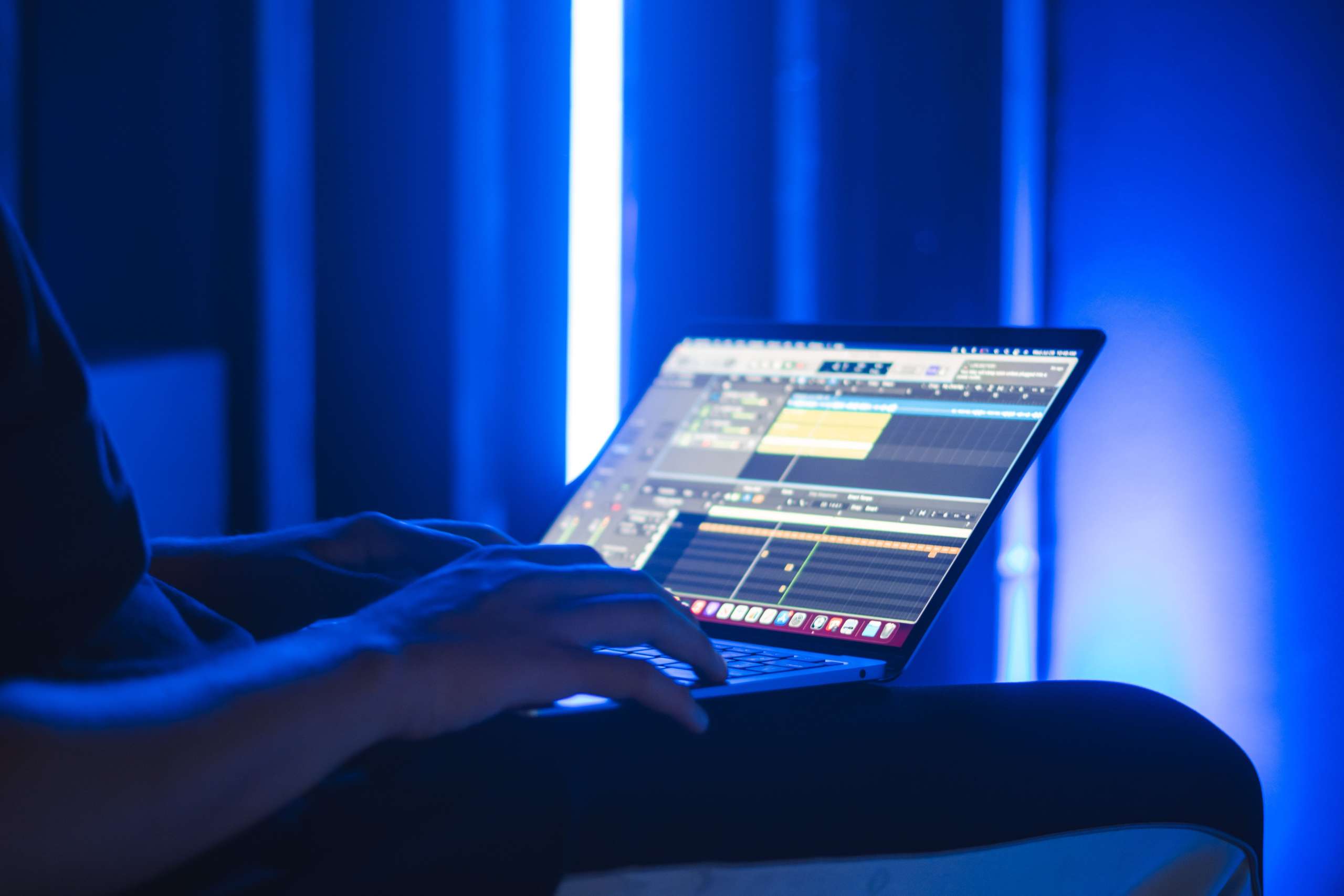 music production laptop at work in a home recording studio